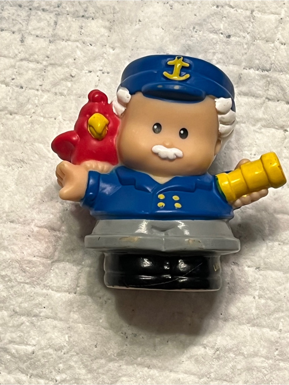 Blue Captain Figure Toy with Red Parrot and Yellow Telescope
